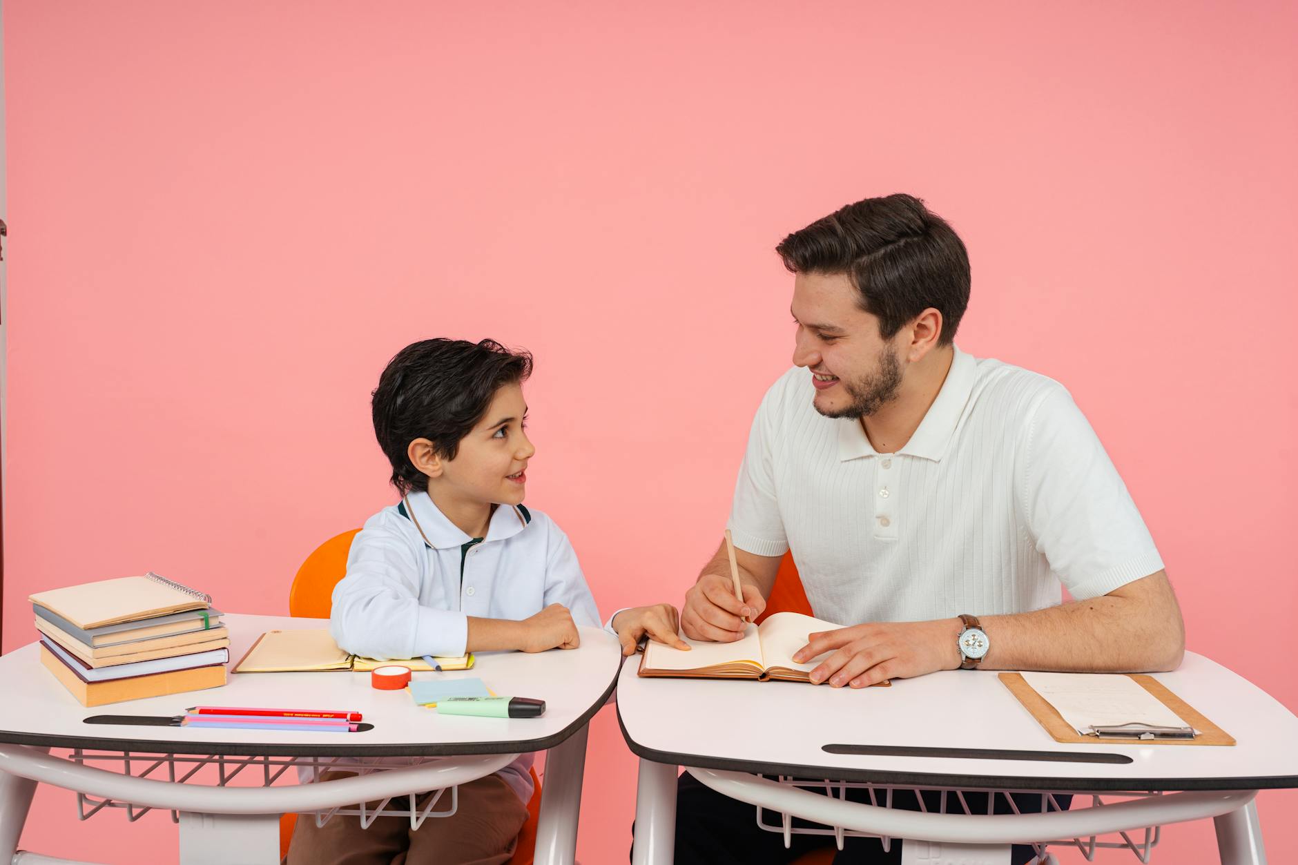 An instructional coaching professional points to a colorful data chart while discussing strategy with a colleague.