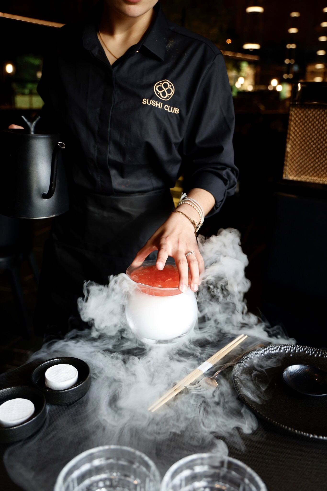 a black plate topped with sushi and chopsticks
