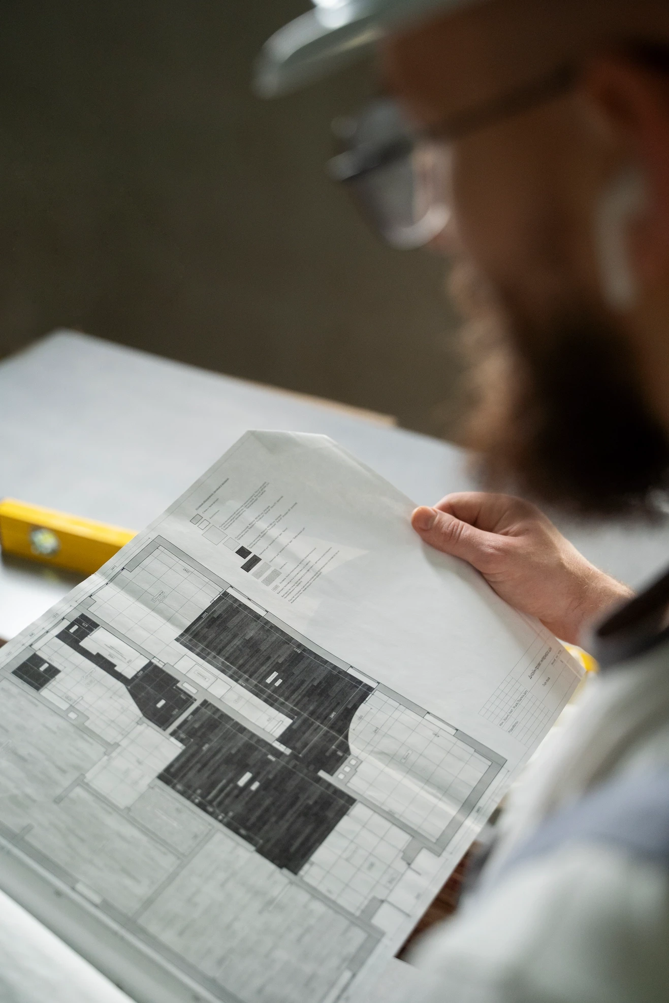 Builder in a hard hat reviewing detailed construction floor plans