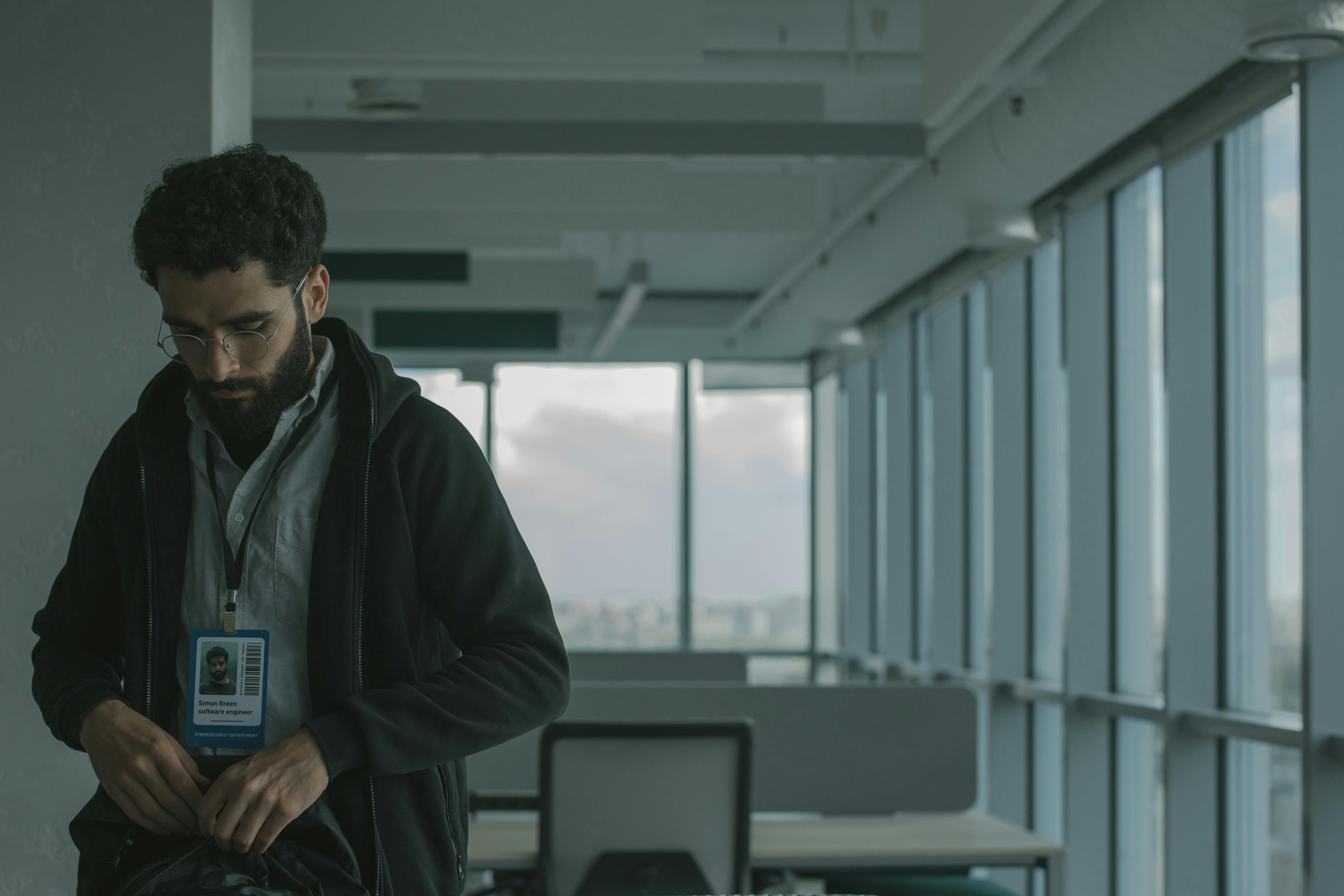 White collar over 40 in ufficio moderno, momento di distacco e riflessione sul lavoro attuale, simbolo di insoddisfazione professionale e perdita di motivazione nel percorso di carriera.