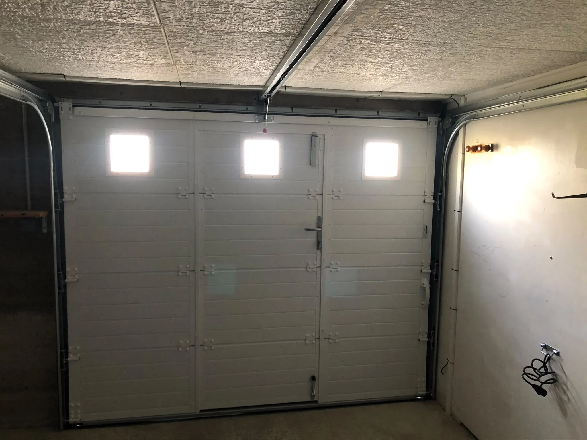 Face intérieure d’une porte de garage blanche — AFermetures