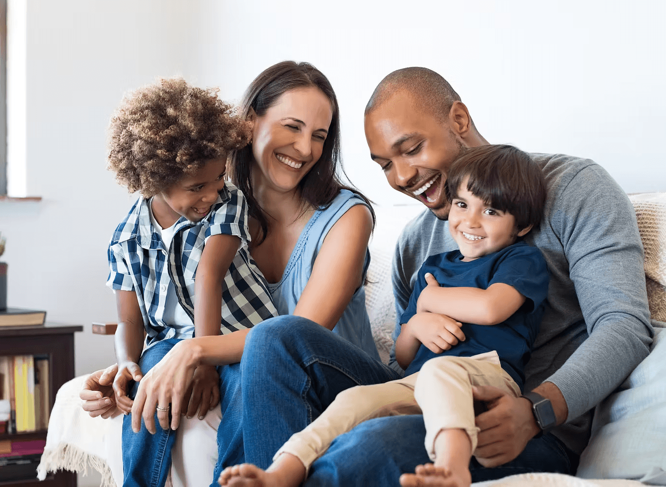 A winding road cuts through rocky terrain, surrounded by patches of green grass and illuminated by sunlight.