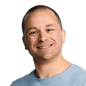 Profile portrait of a man in a white shirt against a light background