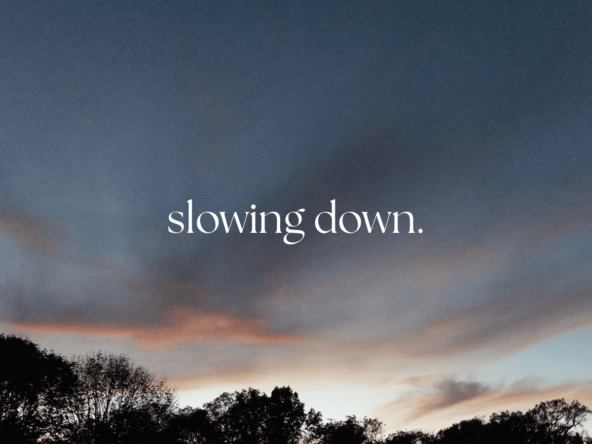 an evening sunset sky with the words "slowing down." in white