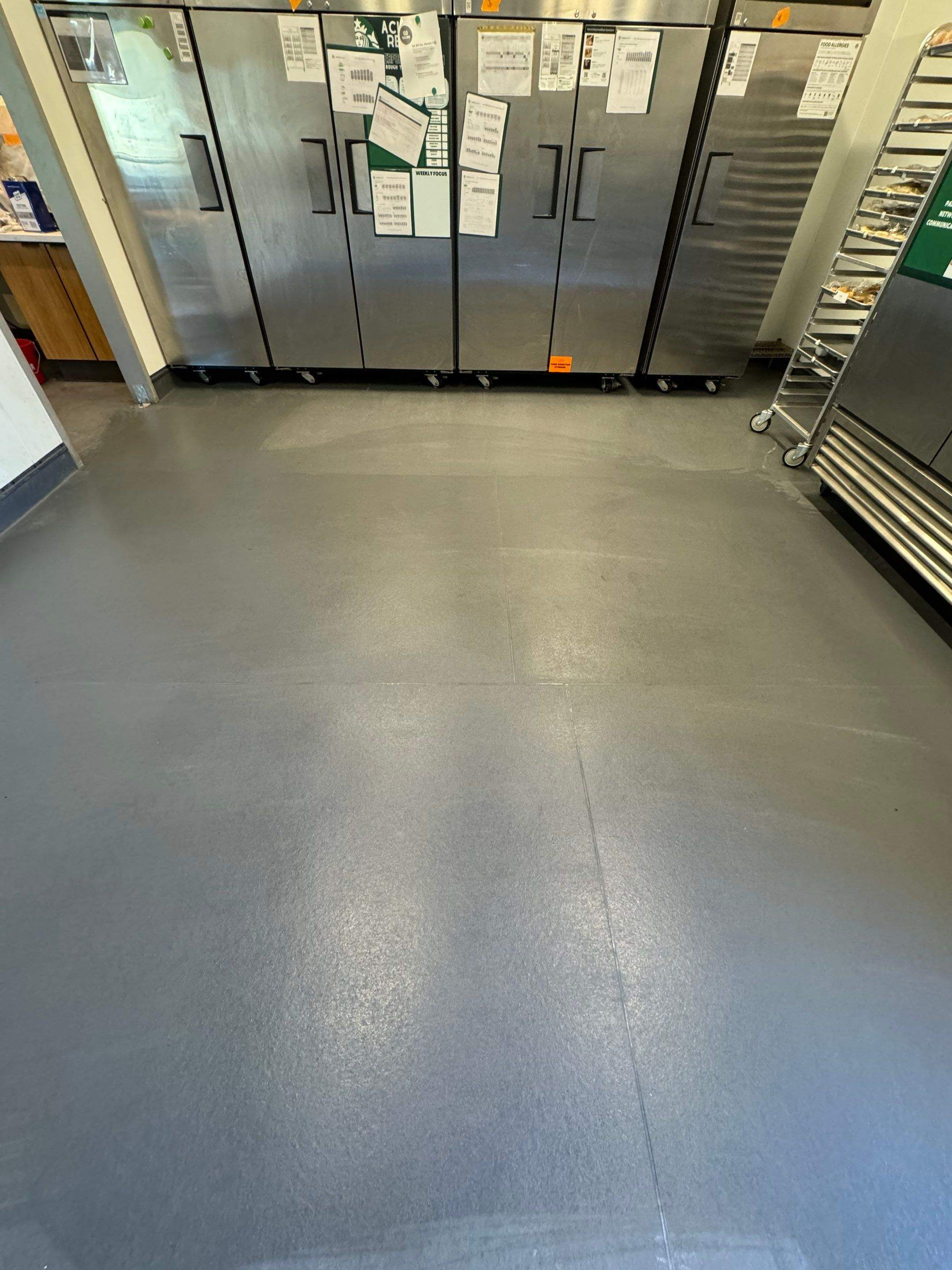 Wide-angle view of completed Eco-Grip installation in a commercial kitchen with even surface sheen and no visible seams.