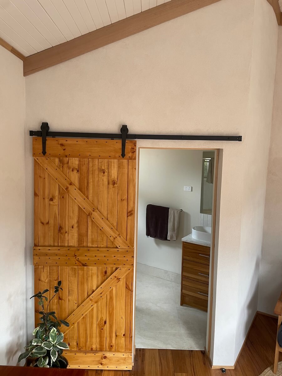 Photo of a door opening to the bathroom showing beautiful hempcrete block wall.