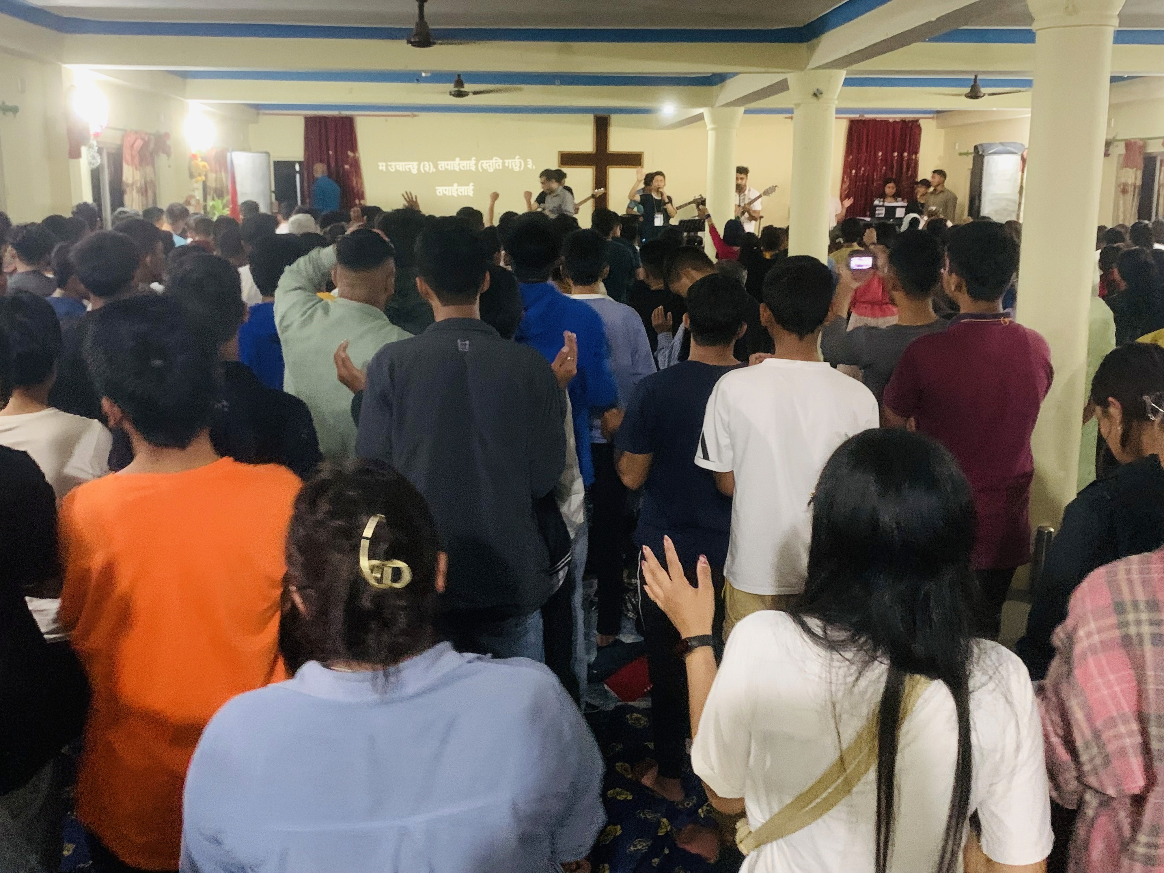 A congregation gathered inside a large hall.