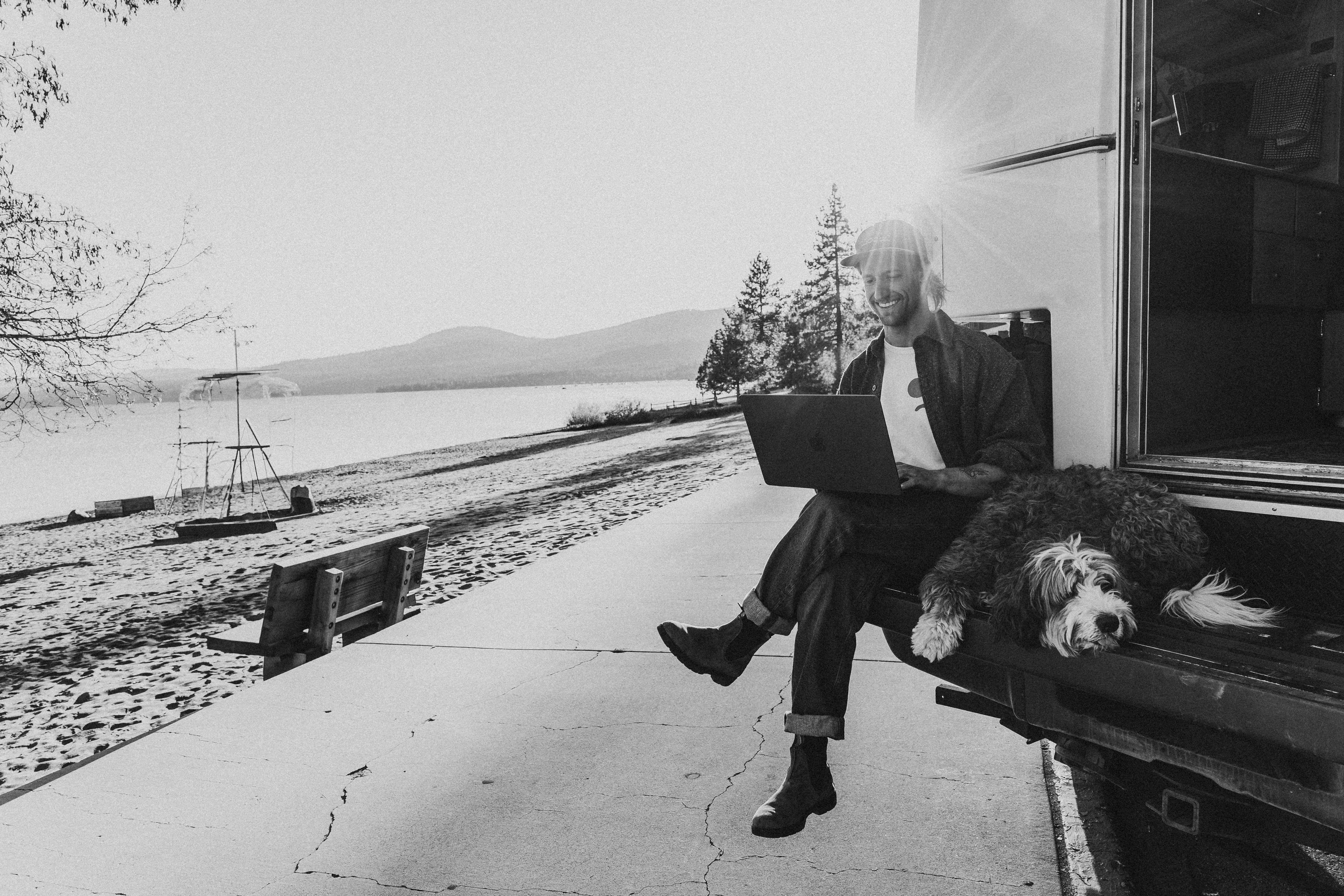 A person sitting in a studio in front of a screen showing the LSDW logo, with a dog at their feet