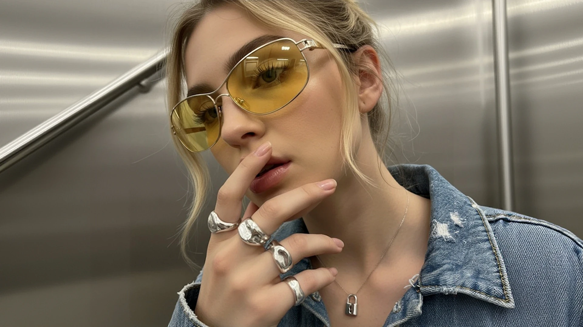 Close portrait woman model with yellow sunglasses in an elevator