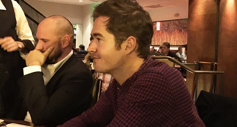 profile portrait of two men sitting at a table