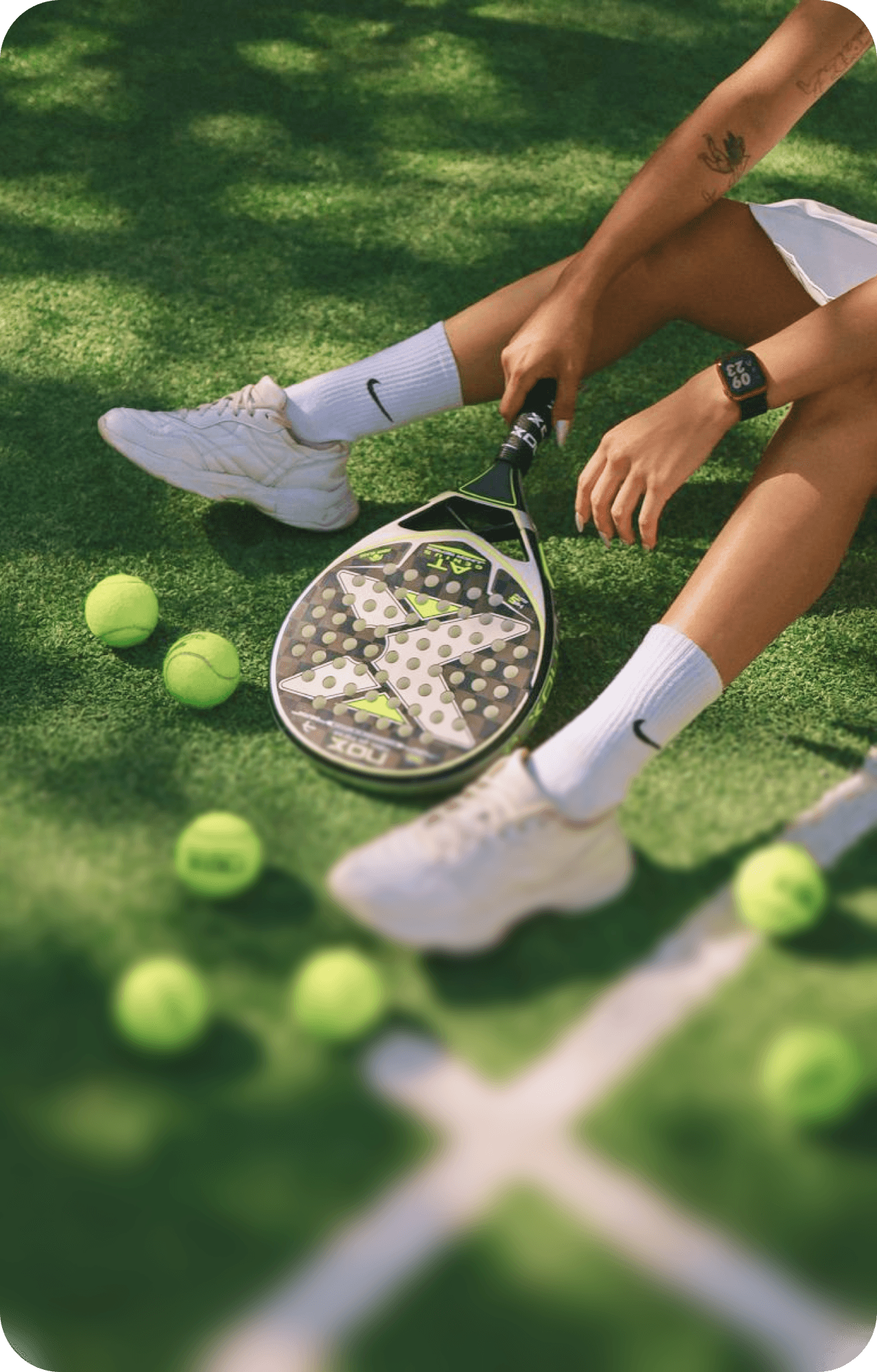 Woman running on an outdoor sports court wearing athletic gear.