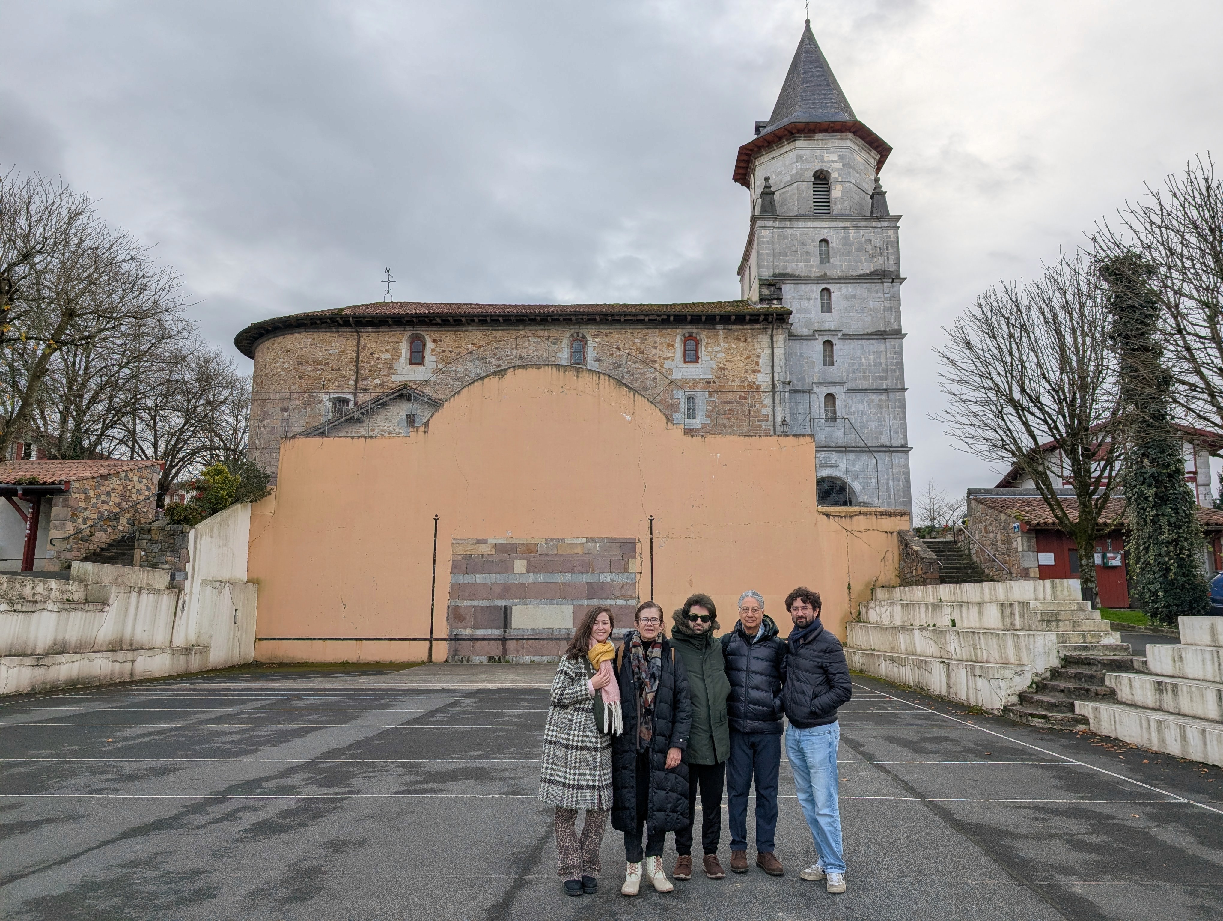 Family group photo in front of a traditional Basque church during a private village visit, at Ainhoa.