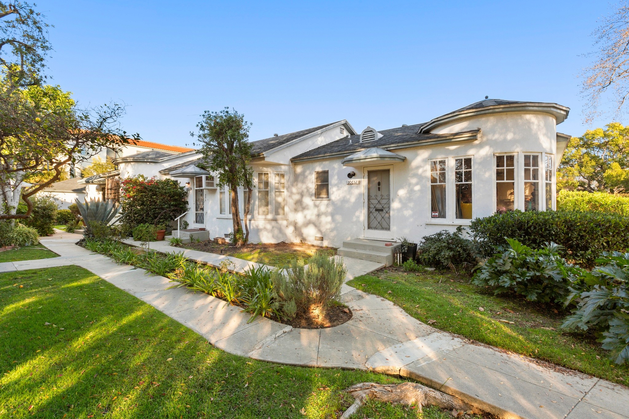 Front courtyard view of a well-maintained Toluca Lake triplex with landscaped walkways at 10651 Whipple.