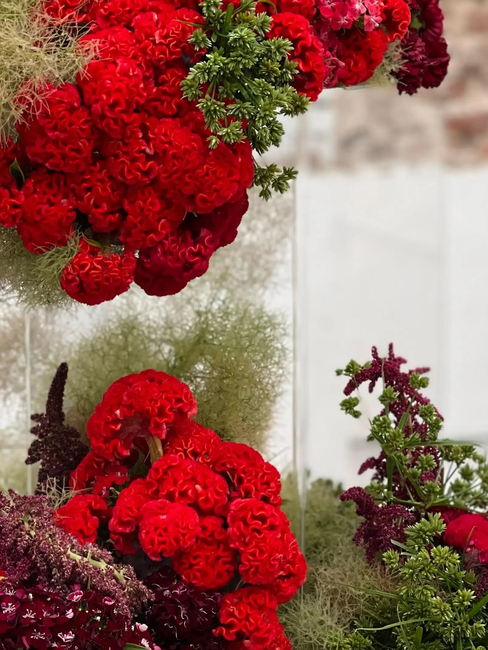 Detalle de flores rojas y verdes en instalación artística para diseñadores florales que exploran volumen, color y textura en espacios expositivos.