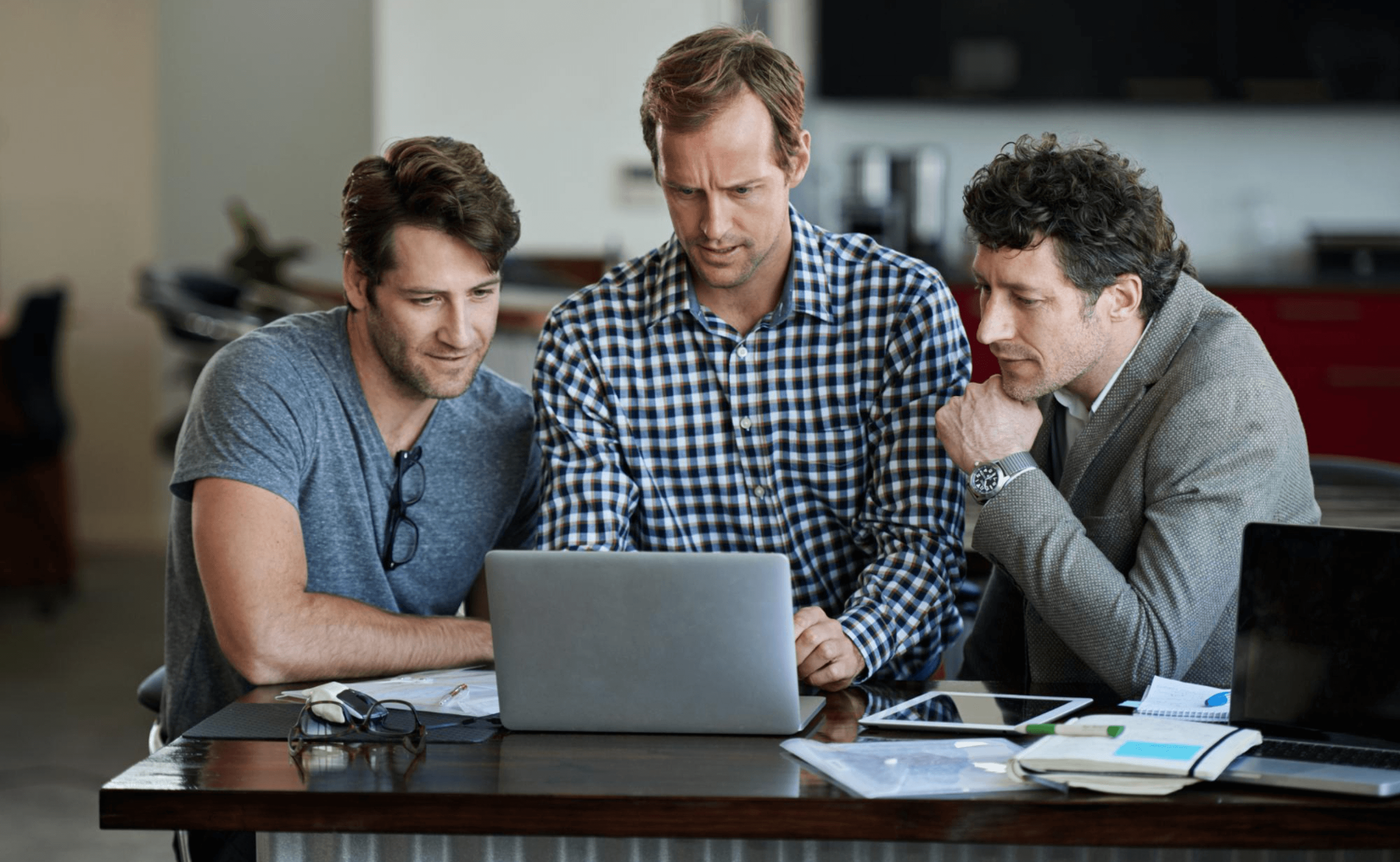 Three people reviewing a laptop together at a table