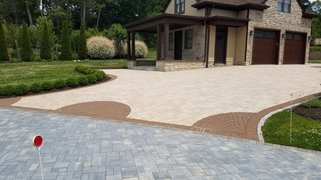 Front driveway with light stone pavers and circular brick inlay pattern