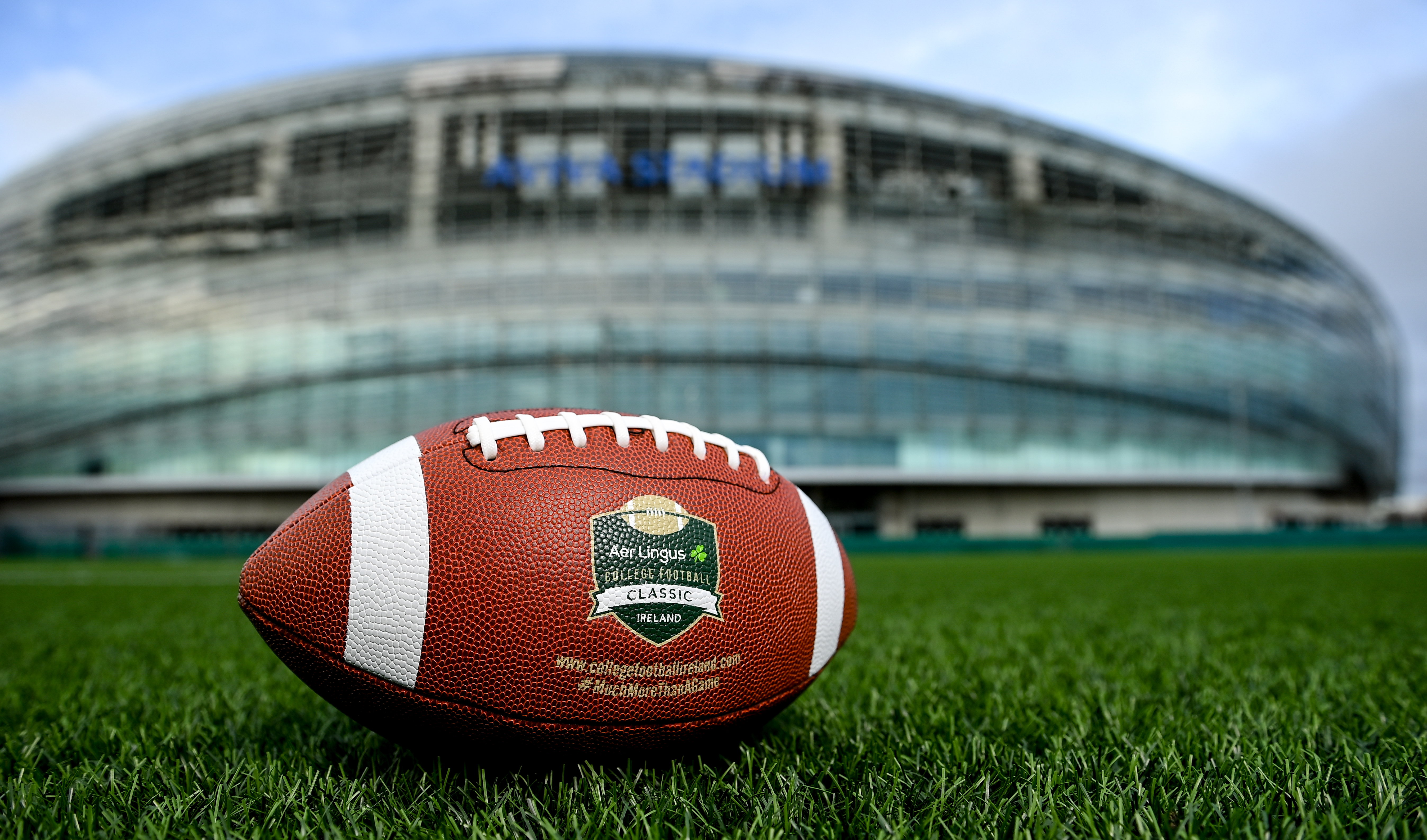 An American football bearing the Aer Lingus College Football Classic logo sits on a field in front of a stadium, symbolizing Investicon's proud partnership with the "More Than Just a Game" initiative. Investicon is more than just an investment conference; it's about community and impact. Join us at the Irish Stock Exchange. #Investicon #AerLingusCollegeClassic #MoreThanJustAGame #Partnership #DublinEvents #CommunityImpact