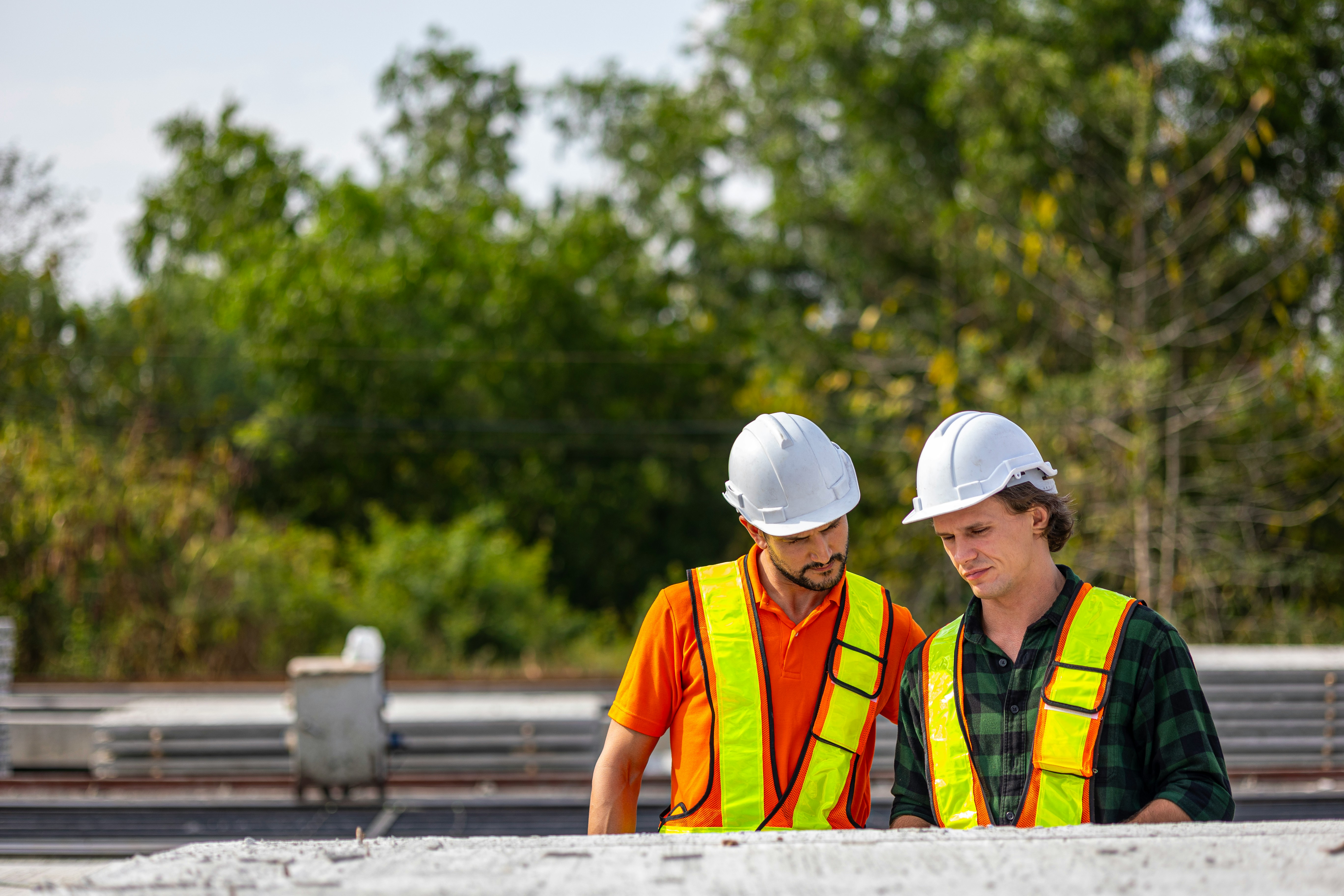 Construction workers examine plans on site.