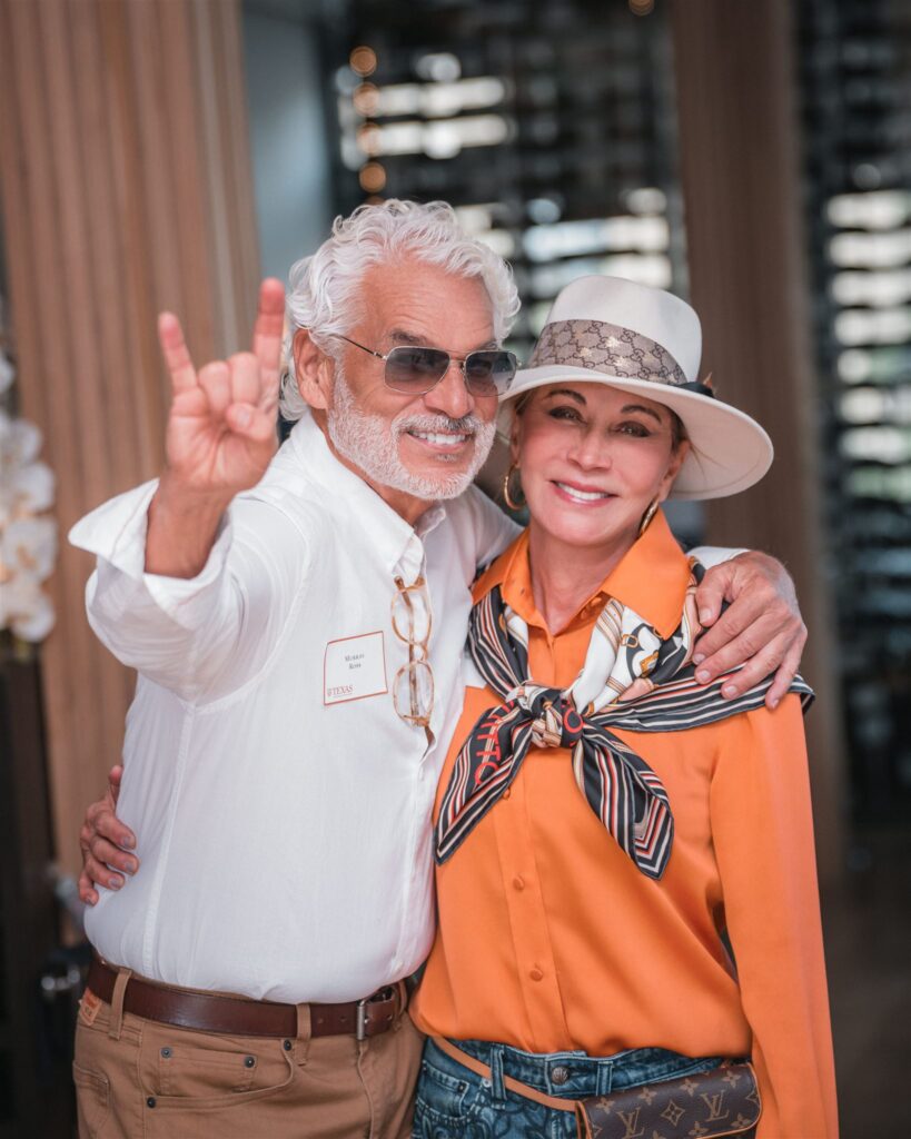 Two event guests posing together in colorful outfits