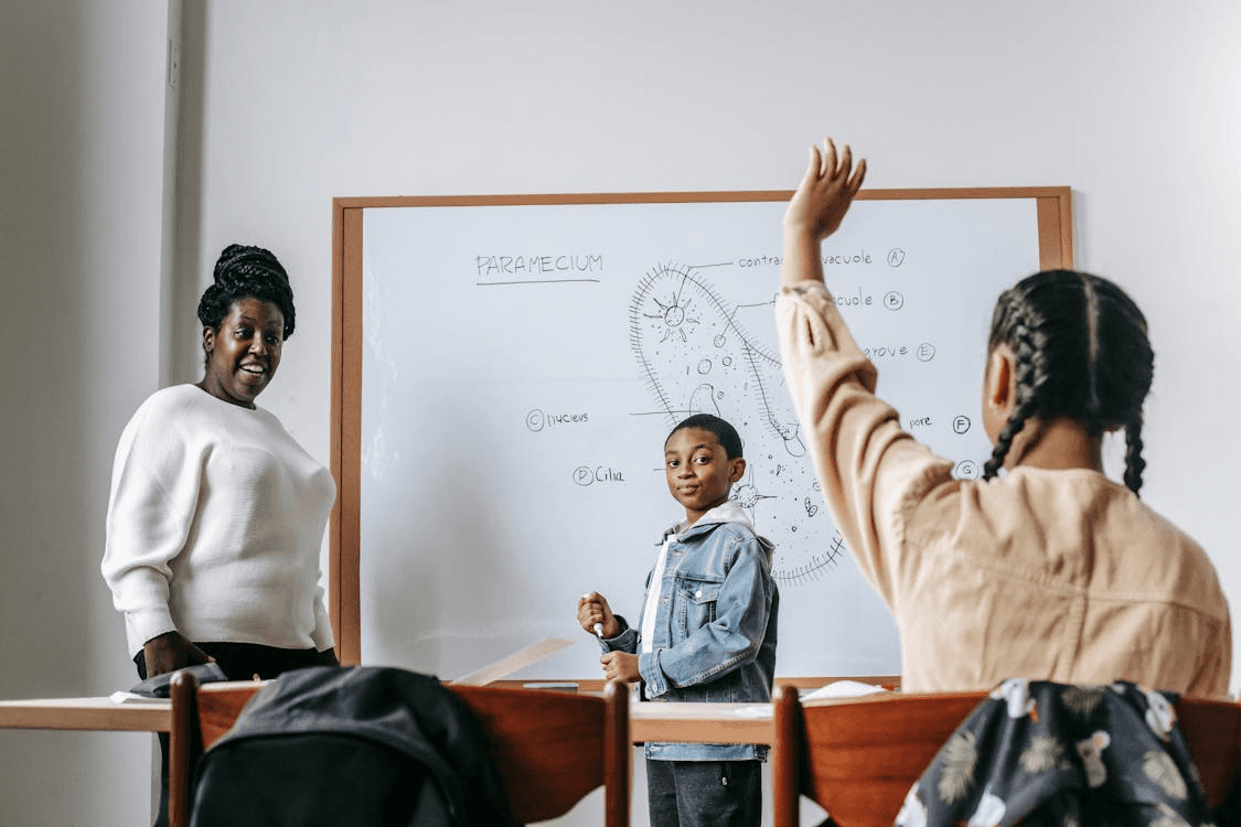 Black woman and students during lesson