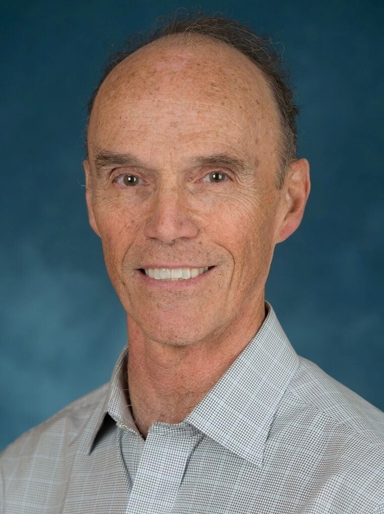 man wearing blue polo shirt with building background
