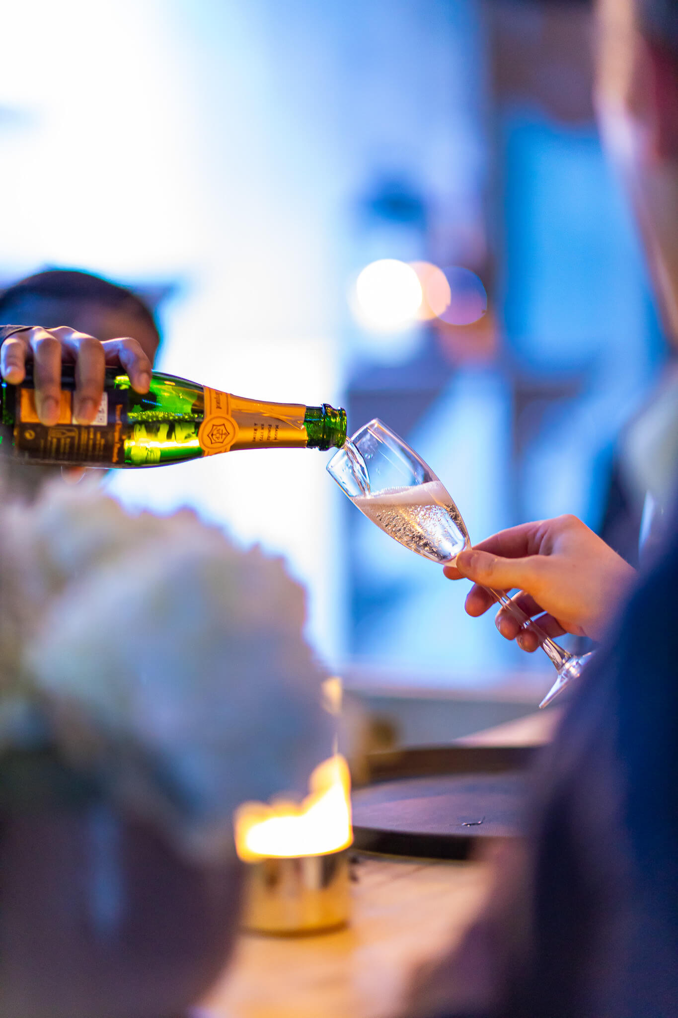Champagne being served during a private evening event with warm ambient lighting