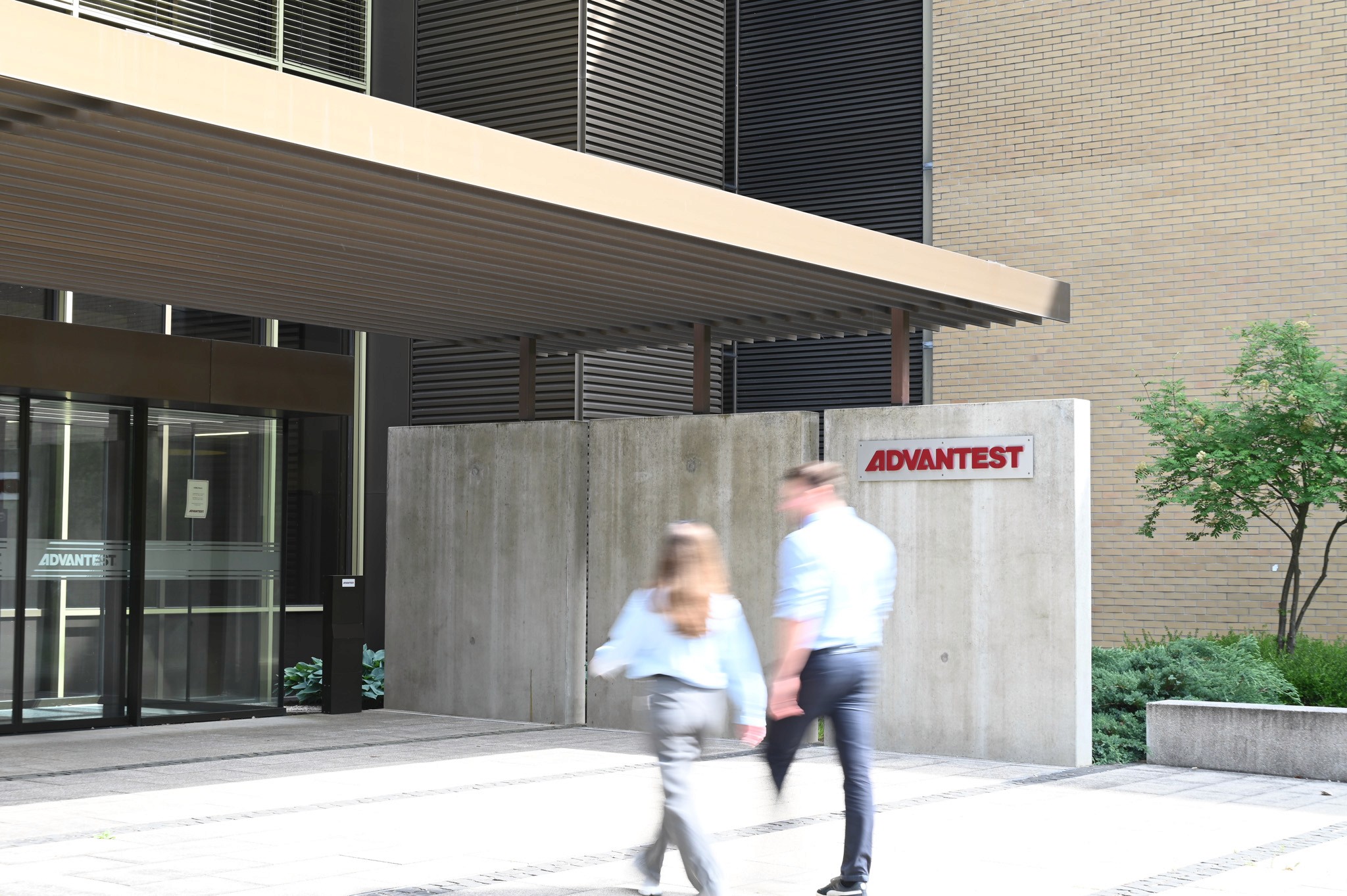 Intrarea a sediului Advantest Stuttgart cu angajati in miscare