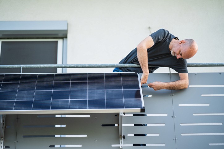 Nahaufnahme von Solarpaneelen mit einem Raster aus dunklen Zellen und dünnen silbernen Linien, die sie miteinander verbinden.