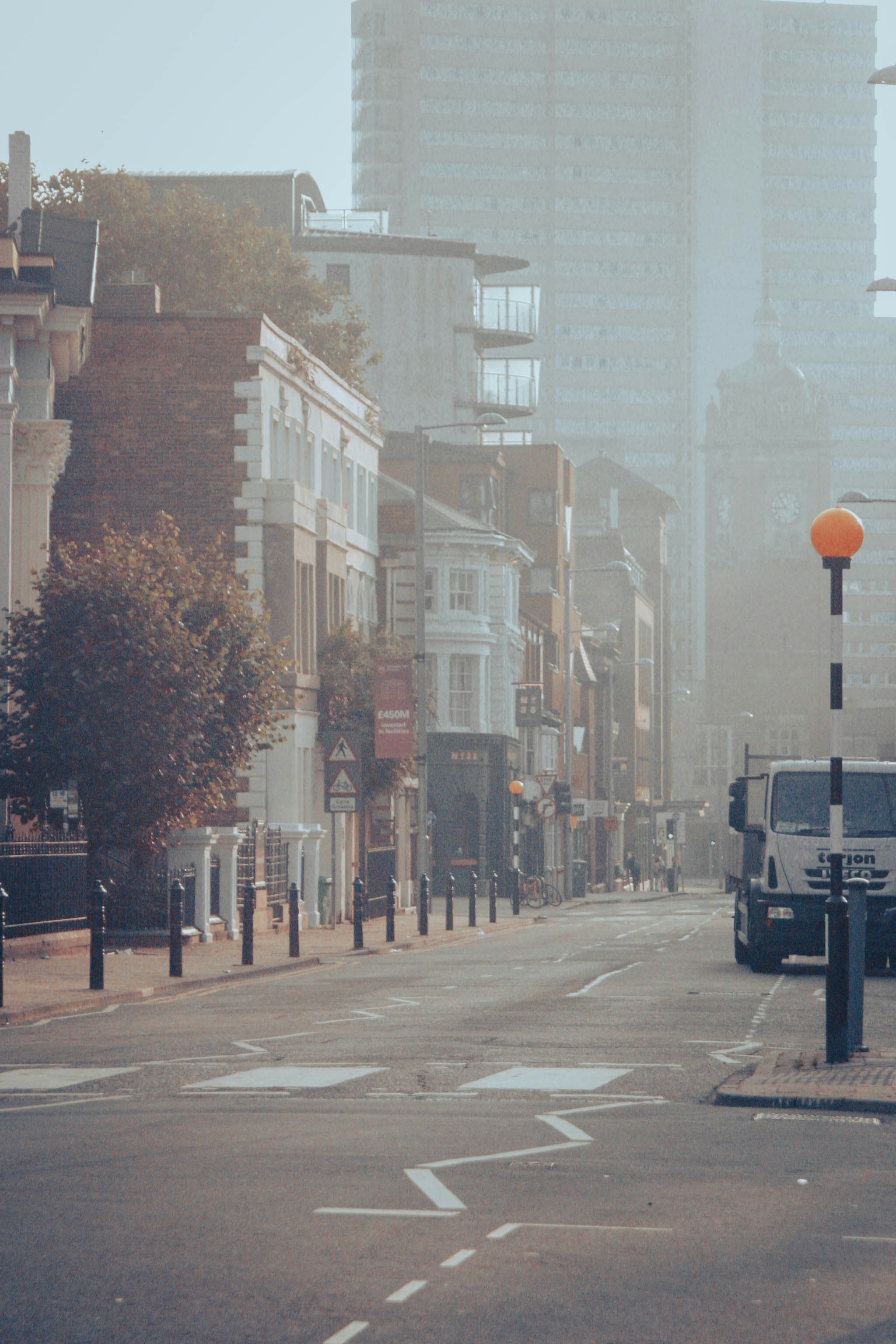 a city street with tall buildings in the background