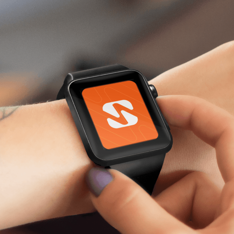 Smartwatch met oranje app-icoon op het scherm in een hand.