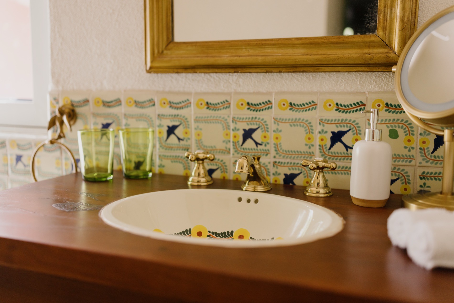 La Residencia bathroom vanity with Talavera bird tile and gold-framed mirror