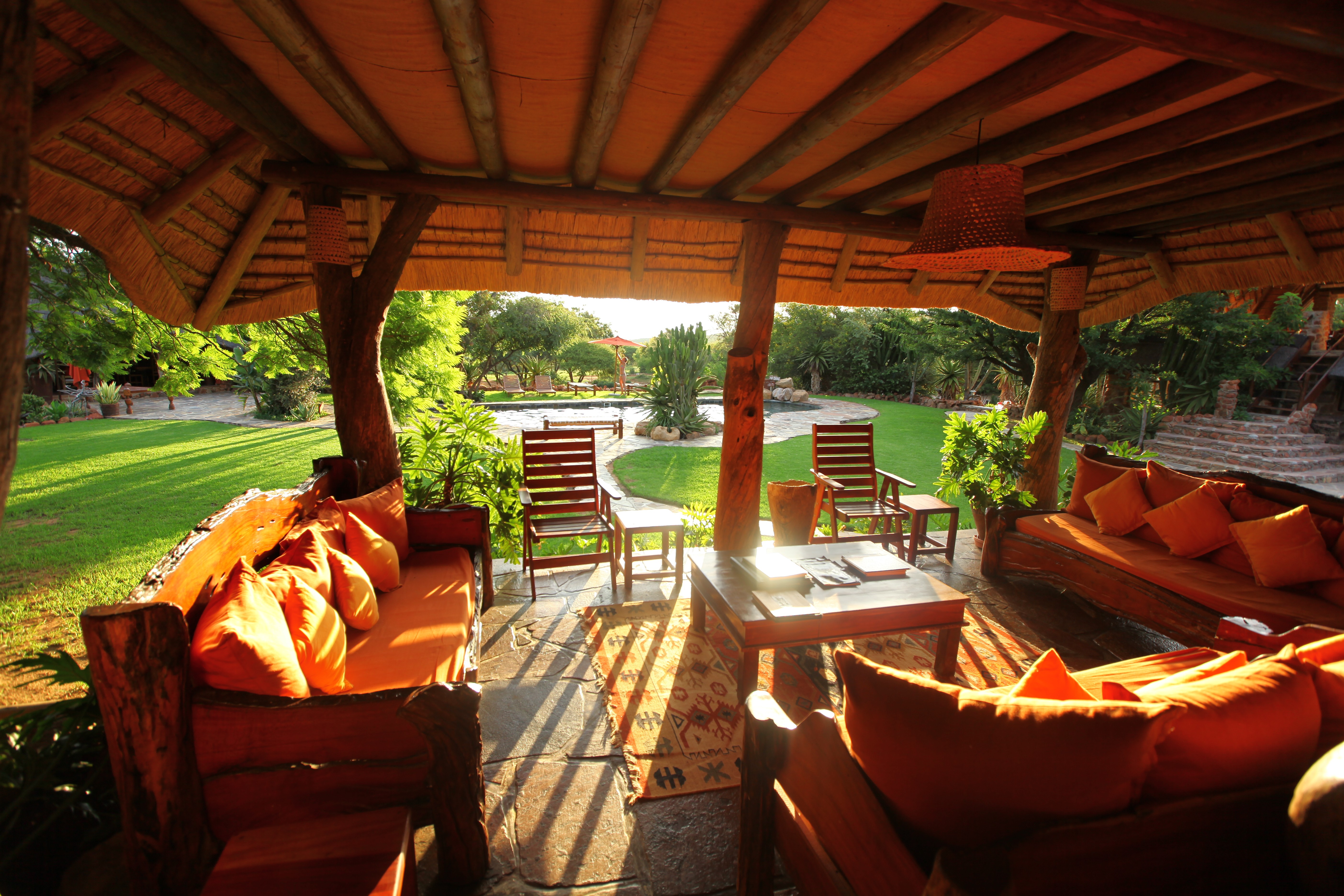 Grupp av ryttare på ridresa i Afrika galopperar över Serengetis vidsträckta slätter medan damm och gnuhjordar rör sig över horisonten under the great migration.