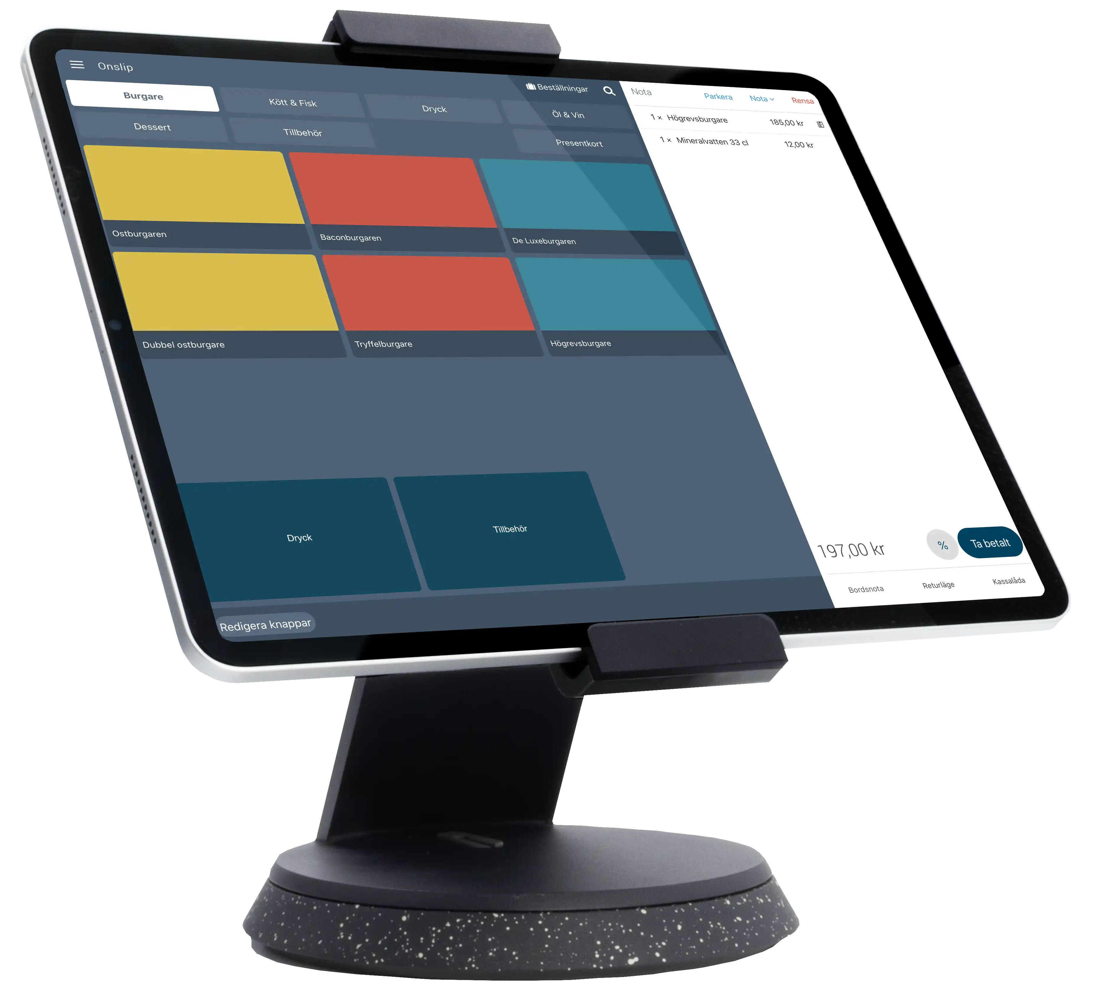 A young person with curly hair smiles at the camera while sitting in front of a laptop against a dark background.