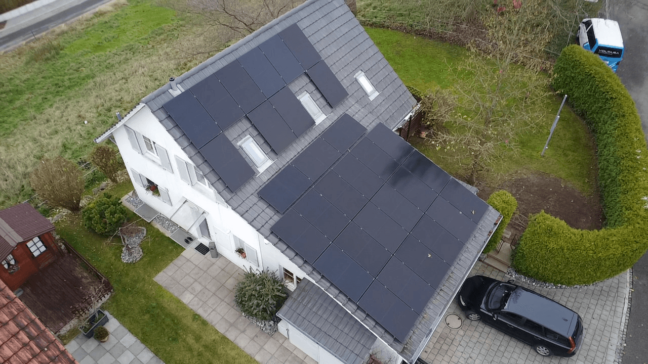 Schräge Luftansicht einer effizienten 15 kWh Photovoltaikanlage auf einem Einfamilienhaus in Ellikon an der Thur, Kanton Zürich.