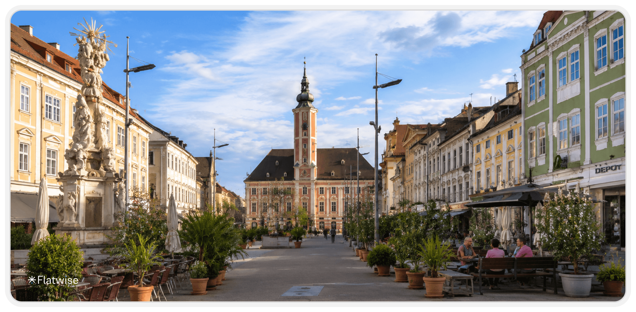 Historischer Platz in St. Pölten mit barocker Dreifaltigkeitssäule, farbenfrohen Altstadthäusern und gemütlichen Gastgärten. Die Szene zeigt den Platz aus einer neuen Perspektive bei sonnigem Wetter und blauem Himmel.