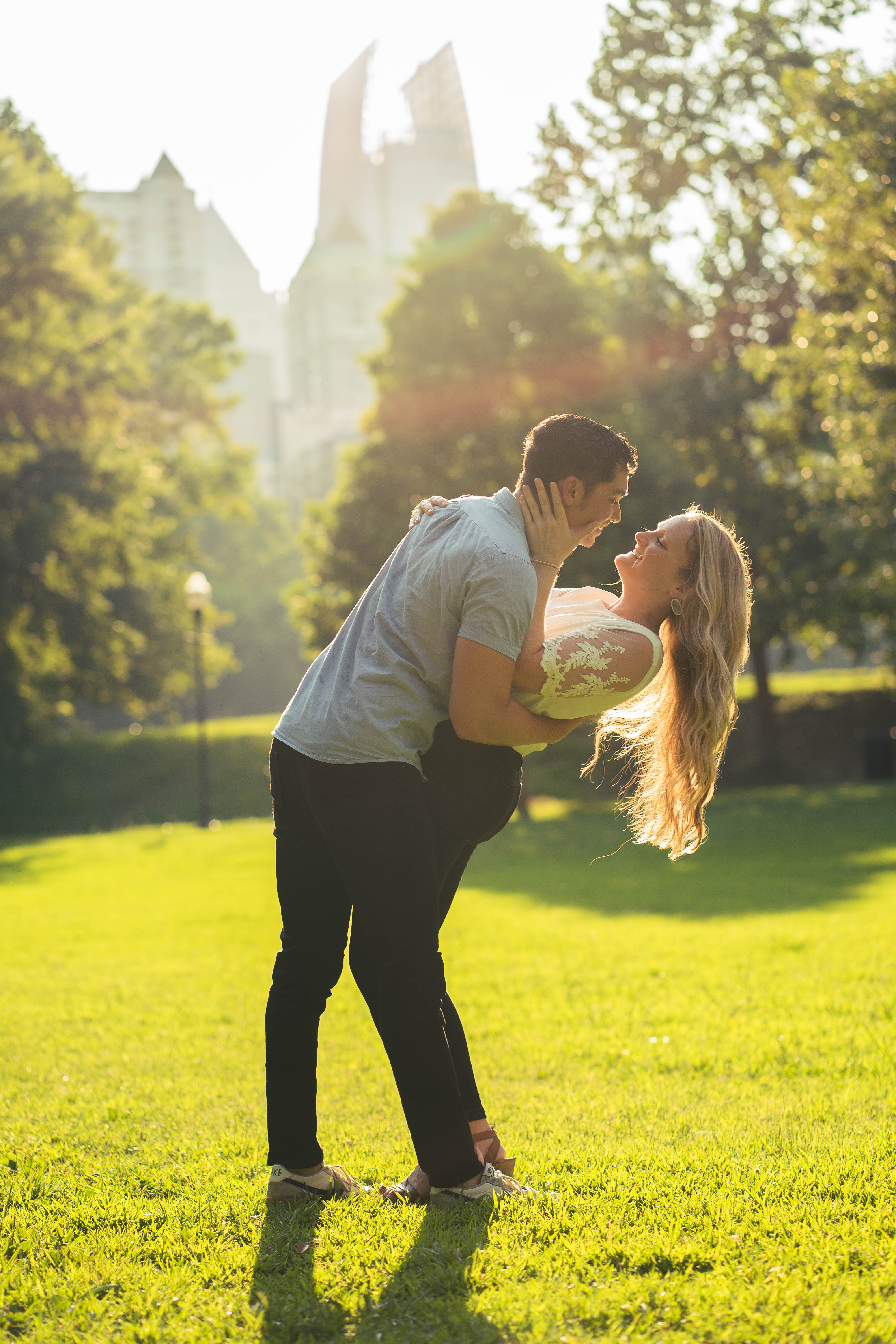 A couple stands outdoors at sunset.