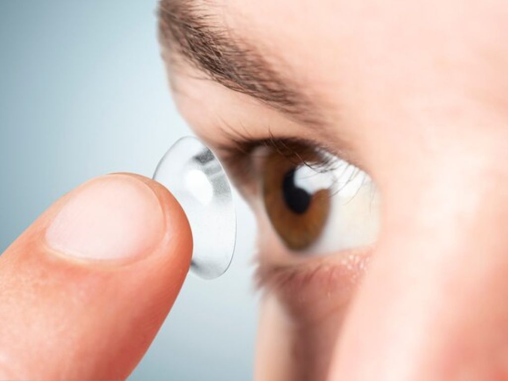 A person inserting a contact lens into their eye, ensuring proper vision correction and comfort.