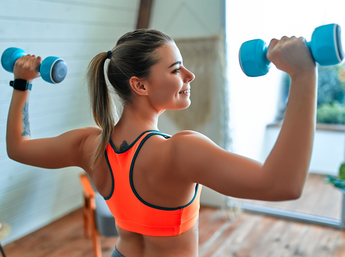 woman using dumbbells as part of her at-home fitness weight loss program