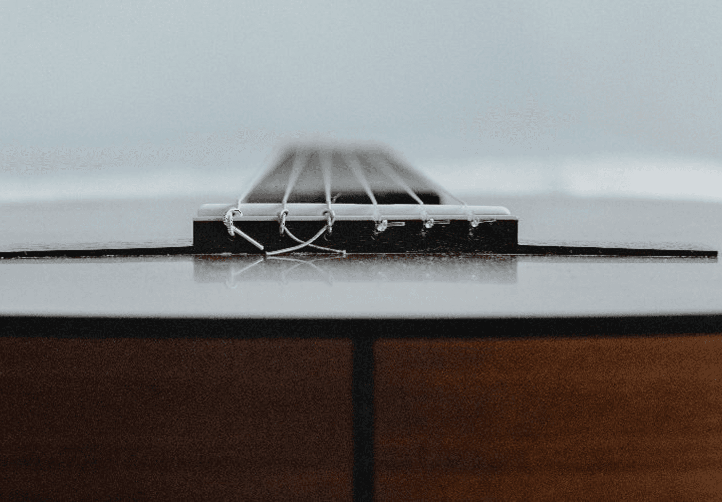 A guitar laying flat staring at the bottom neck