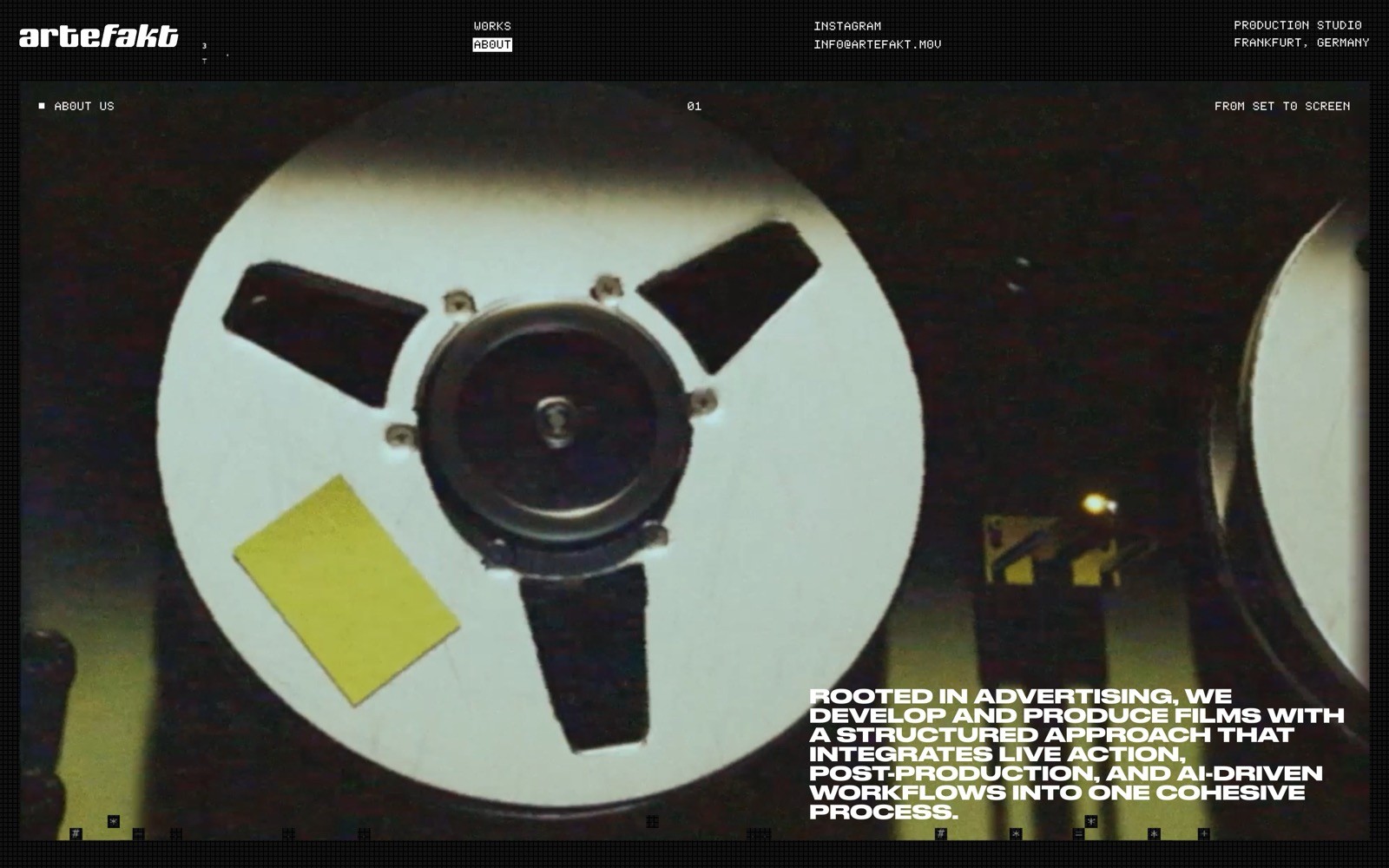 Close-up of a white reel-to-reel tape with a yellow sticky note on it.