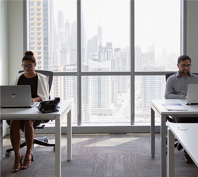 Two employees working at parallel desks, designed for collaboration and effective teamwork.