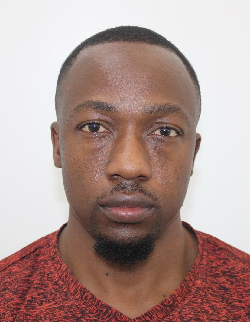 A man with glasses and a brown shirt, crossing his arms.