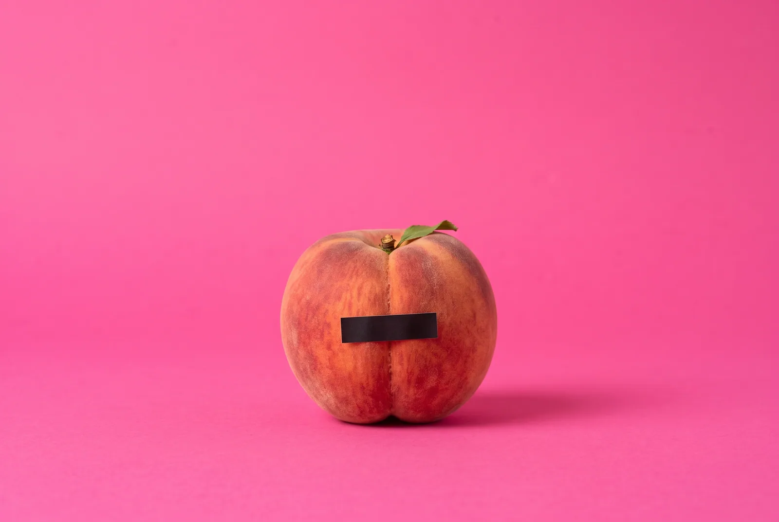 A peach with a small black censor bar sticker, a playful image for how to turn off sensitive content on X