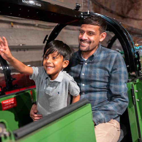 A father and son riding Mail Rail at The Postal Museum