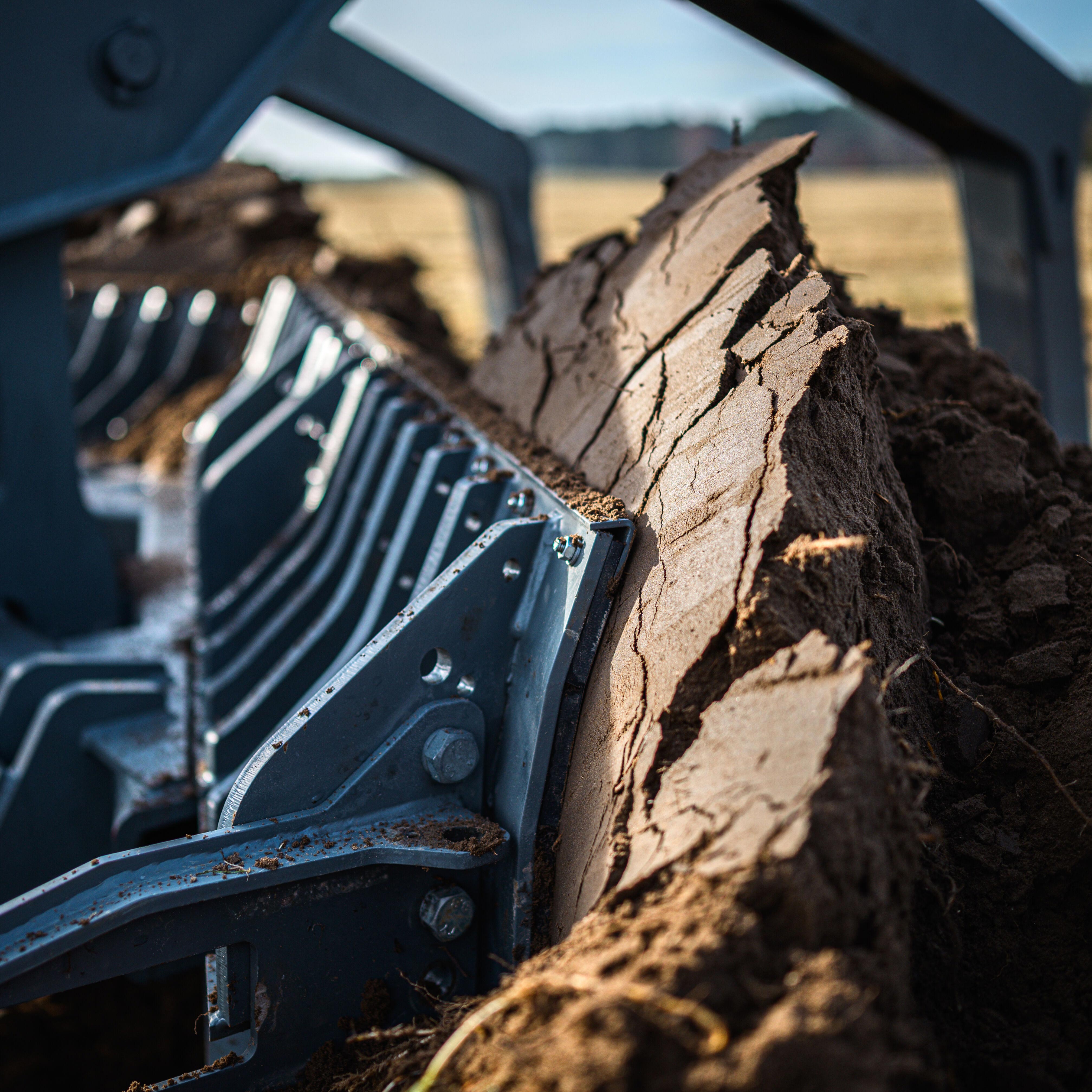 Close-up of GCS Mine Plough cutting through soil during minefield breaching operations.