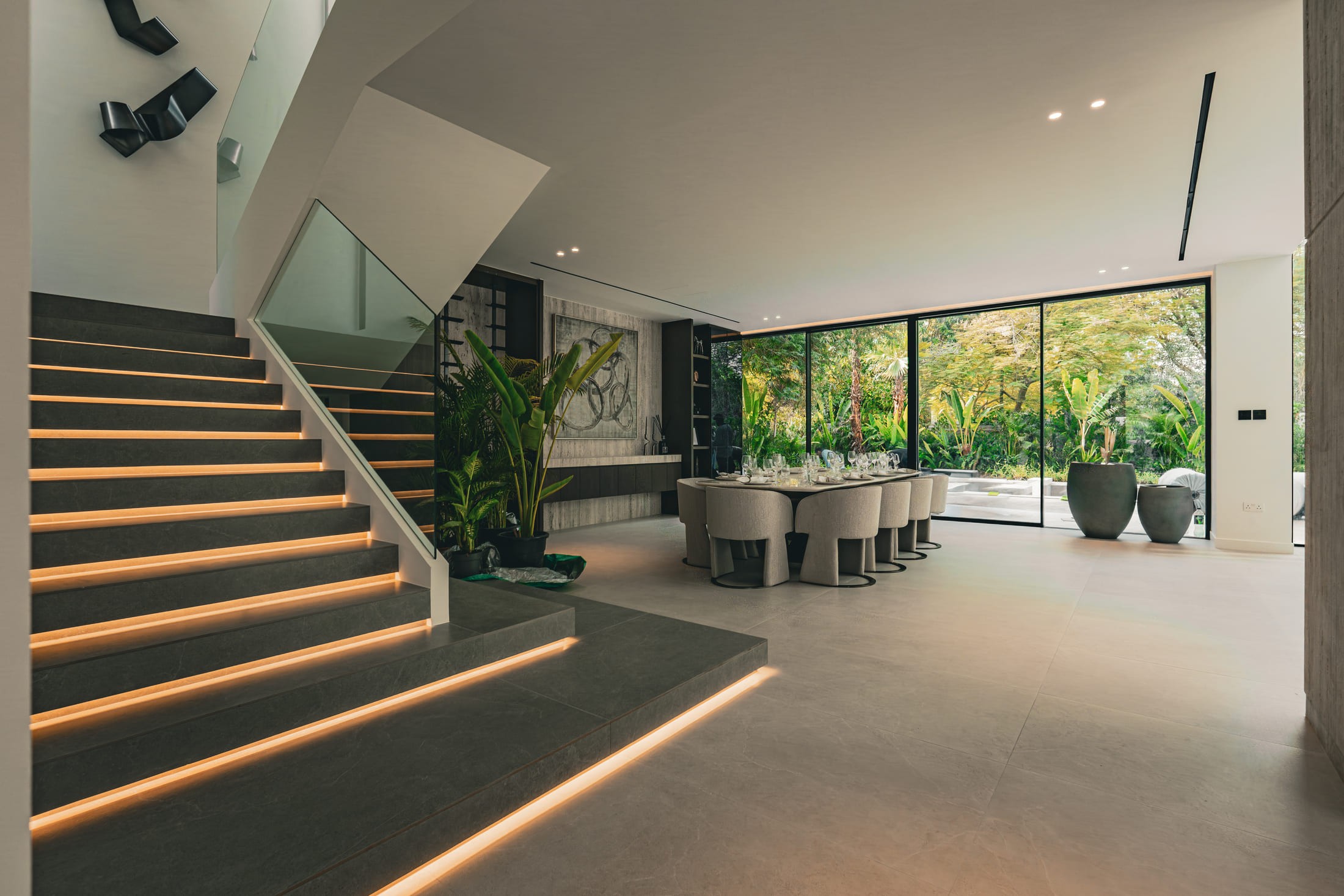 Window of a villa's stairs & dinning table with a big glass window 
