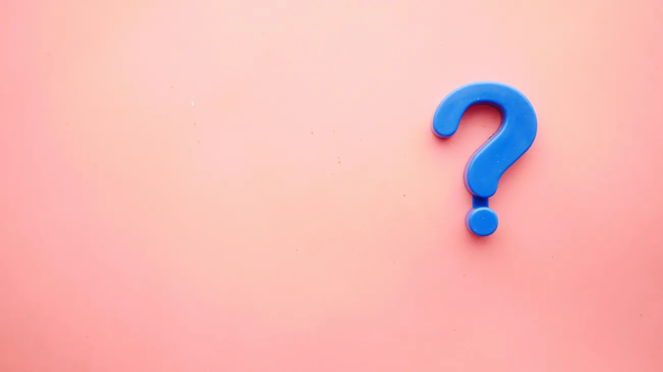 Blue question mark on a pink background, representing frequently asked questions about sports club sponsorship, including pricing, agreements, tax, activations and reporting.