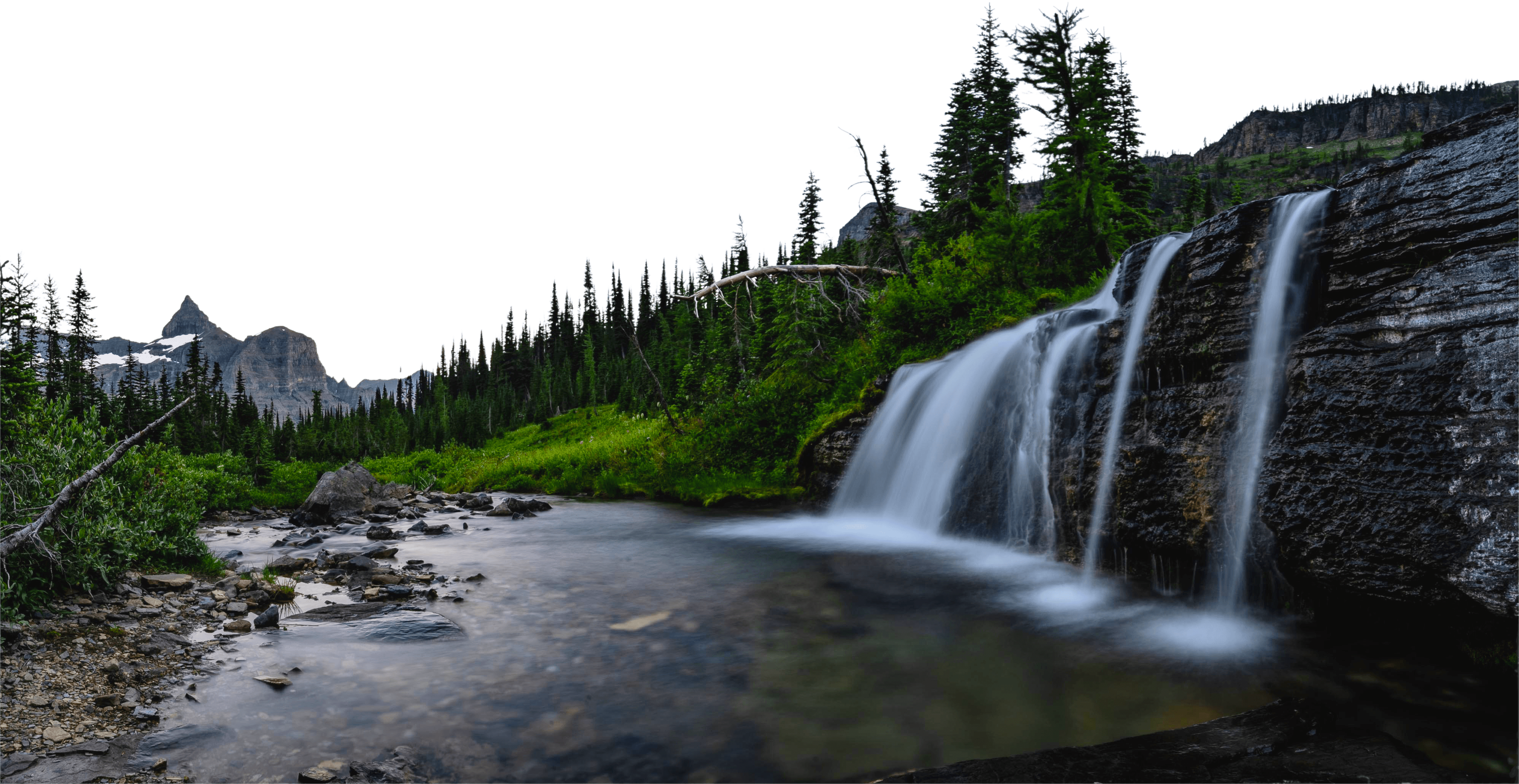 An alpine waterfall flows down a glacier-carved valley