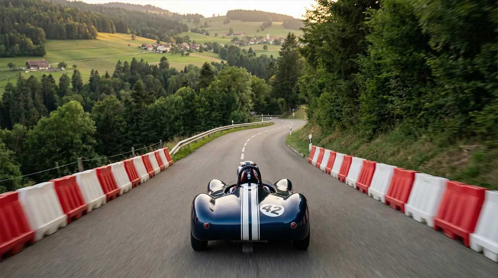 Bolide de speed down bleu numéro 42 en pleine descente entre les barrières de sécurité sur la route de St-Cergue, Coupe d'Europe 2026