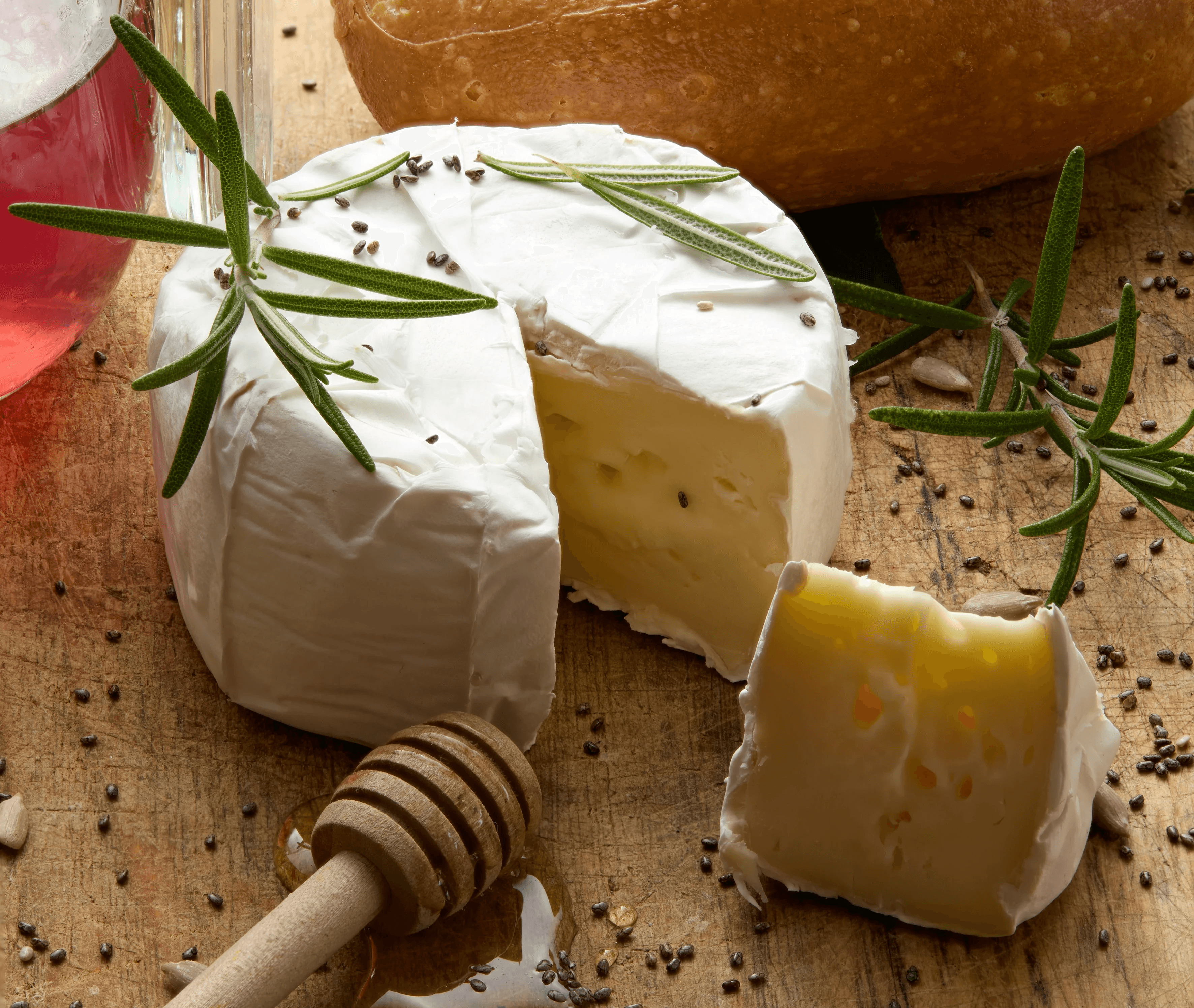 Cheese, bread, and honey on a wooden board.